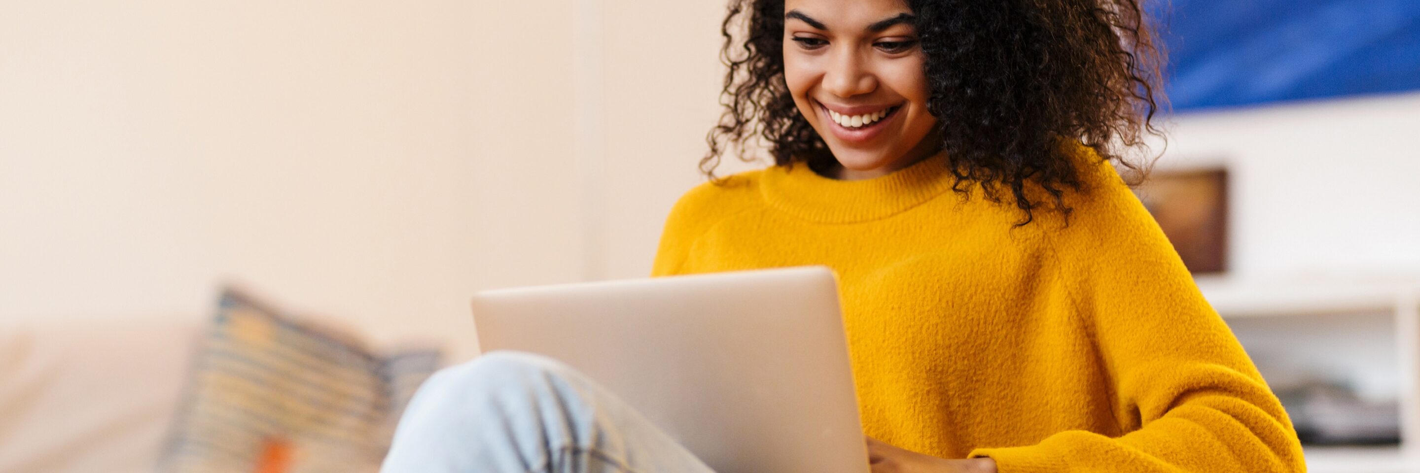 Image of african american woman using laptop while sitting on chair