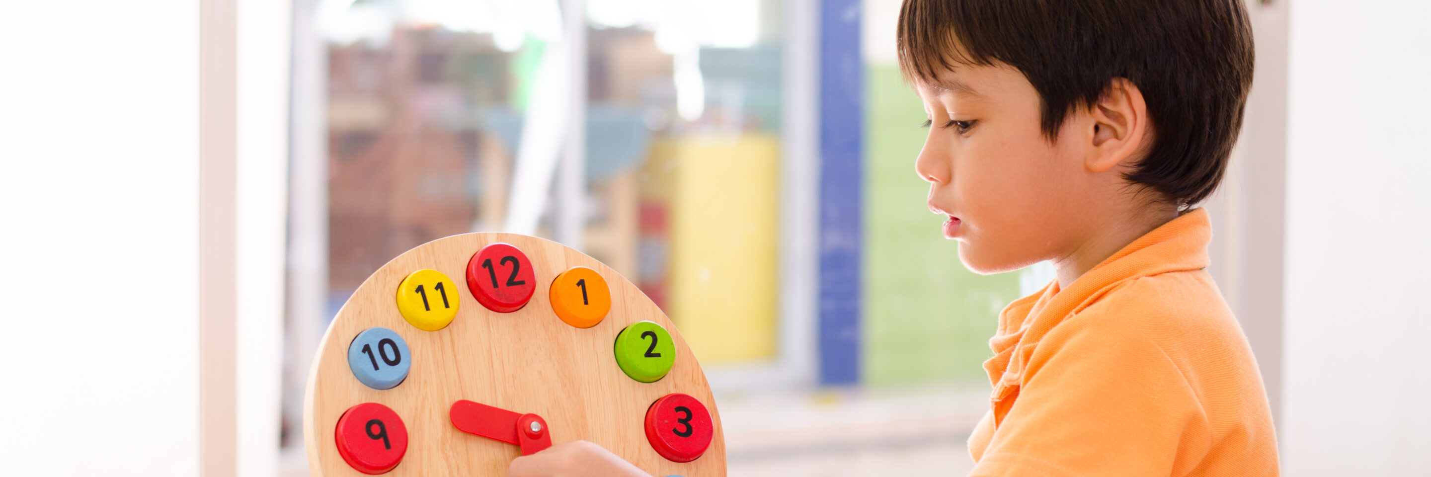 Little boy learning time with clock toy of montessori