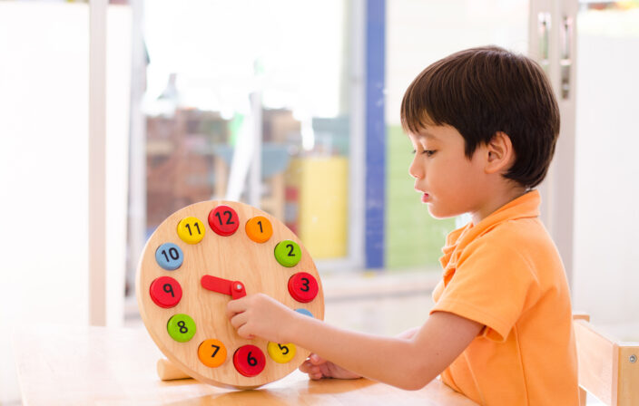 Little boy learning time with clock toy of montessori