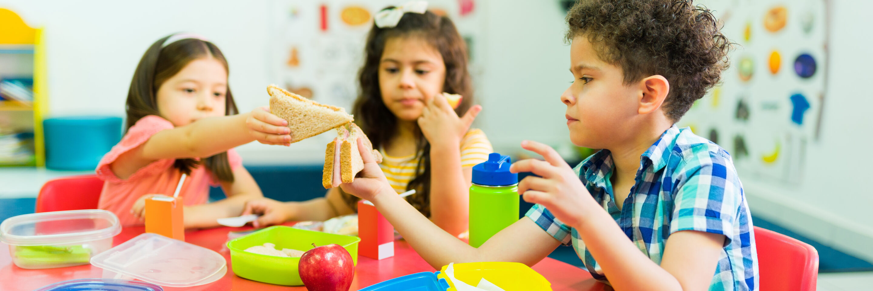 Kindergarten kids learning to share their lunch food