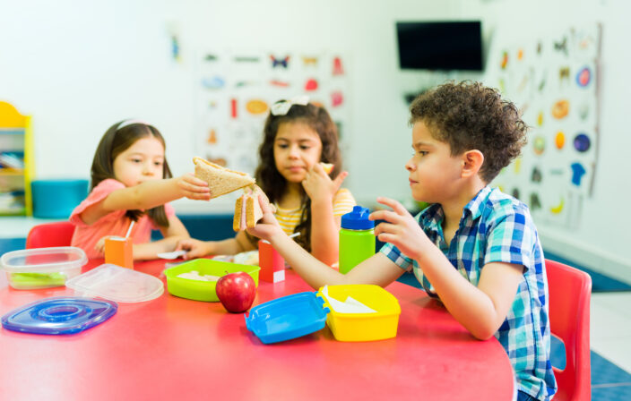 Kindergarten kids learning to share their lunch food